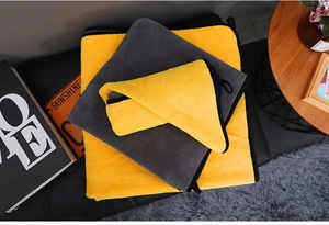 Detail of three thick coral fleece pet towels with reinforced edges and hanging loops