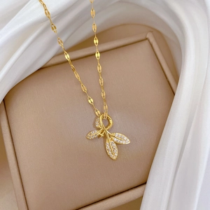 Macro shot of gold-plated titanium leaf pendant necklace with crystals in jewelry box