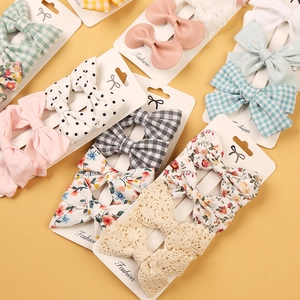 Set of four bow hair clips for kids in floral, polka dot, and solid fabric patterns