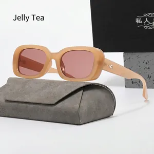 Detail view of retro jelly tea rectangle sunglasses resting on a grey velvet case