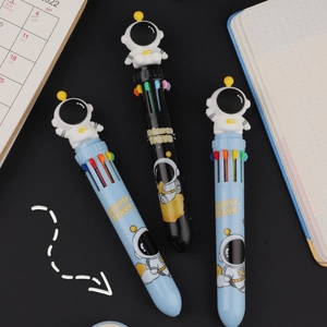Detail of three multi-color ballpoint pens with cute astronaut charms on black background