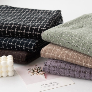 Group of plaid cashmere-like scarves in various colors neatly folded on a clean background