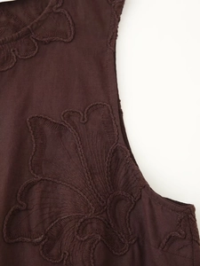Gros plan de broderie florale sur haut sans manches en coton et lin marron foncé