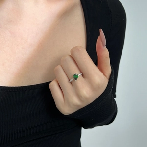 Detailed macro view of pear-cut green gemstone and white zircon on S925 silver ring