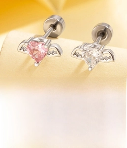 Macro detail of titanium steel heart wing earrings with pink and white zircon stones