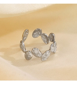 Macro shot of silver irregular oval ring with hammered texture on satin fabric