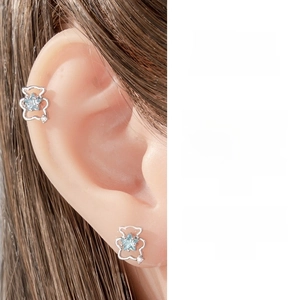 Close-up of bear-shaped silver stud earring with a light blue star-shaped zircon
