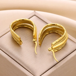 Macro shot of 18K gold-plated C-shape earrings with layered textured metal details