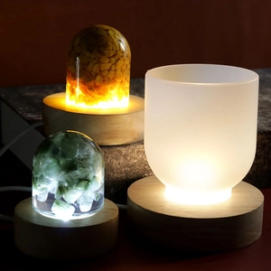 Three crystal resin night lights with solid wood bases showing warm lighting effects
