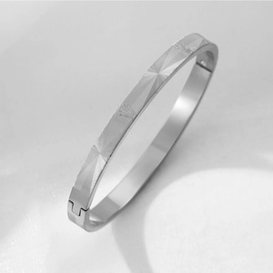 Detailed close-up of silver titanium steel bracelet with crown grid pattern and snap buckle