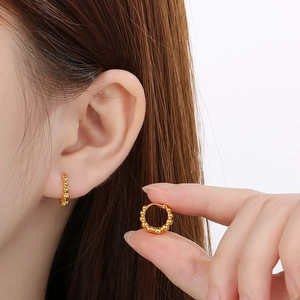 Minimalist gold beaded hoop earrings shown on ear and held in hand for scale detail