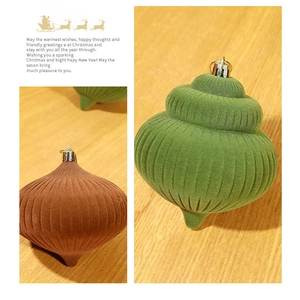 Detailed view of flocked onion shaped Christmas ornaments in deep green and earthy brown tones