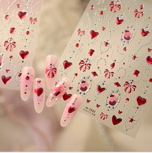 Macro-detail van 3D-nagelstickers met roze harten en rode strikken voor Valentijnsdag