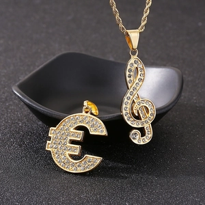 Close-up of gold iced-out treble clef and euro symbol pendants with crystal rhinestones