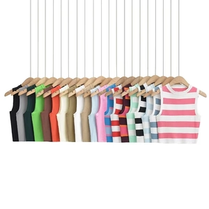 Macro view of assorted knitted crop tops hanging neatly on a white background
