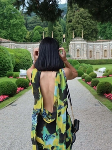 Détail d'une robe dos nu à col en V avec des motifs abstraits colorés dans un jardin chic