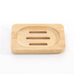 Close-up of a rectangular bamboo soap dish with three drainage slots on white background.