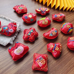 Traditional Chinese New Year red embroidered fabric lucky charms set on wooden background