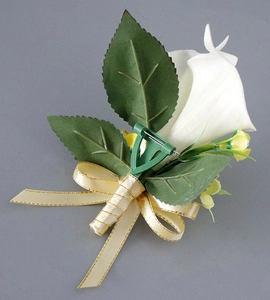 Close-up of artificial white rose boutonniere with green leaves and a yellow ribbon bow