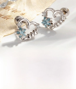 Detailed view of silver heart earring with blue star zircon and titanium steel backing