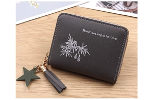 Detail of grey mini coin purse with tassel, star pendant and leaf print on wood background