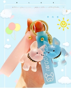 Close-up of pink and blue crystal French bulldog keychains with silicone wrist straps