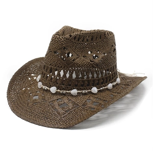Detail of hollow-out weave texture and heart bead band on a brown straw cowboy hat