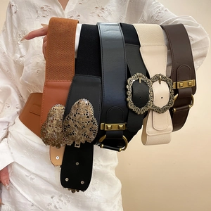 Gros plan de larges ceintures élastiques vintage avec divers modèles de boucles en métal