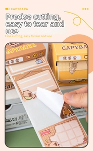 Detail showing the manual tearing of a Capybara themed pull-out sticky note roll