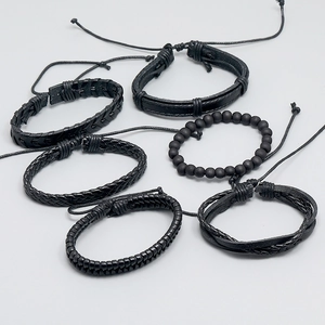 Macro detail of 6-piece black braided leather and matte bead bracelet set for men