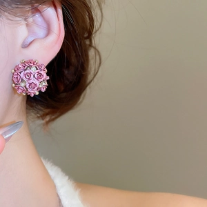 Detail of model wearing pink rose bud stud earrings with sparkling crystal accents