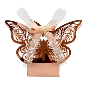 Detail of rose gold laser-cut butterfly wedding favor box with elegant ribbon closure