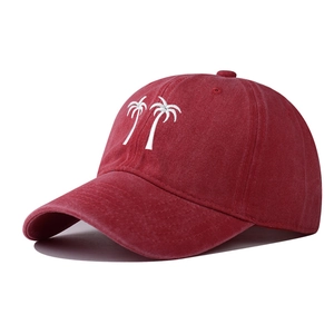 Close-up of coconut tree embroidery on washed red cotton canvas baseball cap
