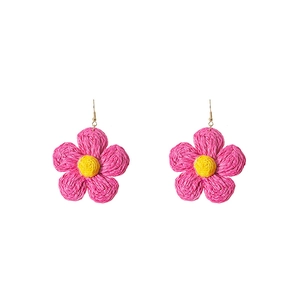 Detail of pink and yellow handmade raffia flower earrings with gold metal hooks