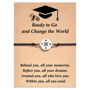 Detail of compass charm bracelet on a graduation card with inspirational quotes