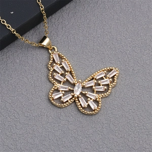 Detail of gold butterfly pendant with baguette cut cubic zirconia on a minimalist chain