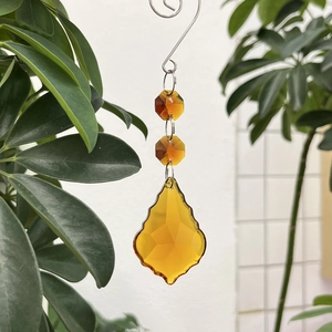 Detail of 50mm yellow crystal maple leaf suncatcher hanging on a metal hook