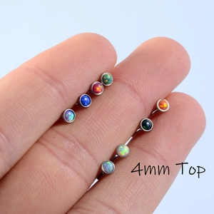 Macro detail of two stainless steel labret studs with 4mm opal tops in vibrant colors