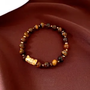 Bracelet en œil de tigre avec breloque chat porte-bonheur dorée sur soie brune