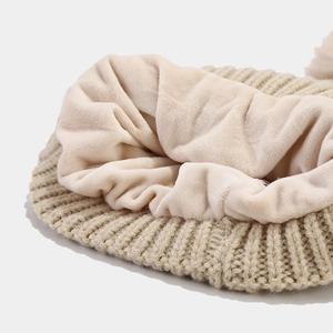 Detail shot of the warm fleece lining and cable knit texture of the winter beanie