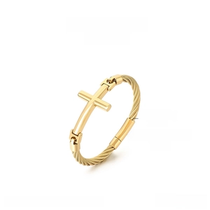 Detail of vintage gold-plated stainless steel cross bracelet with twisted cable wire design