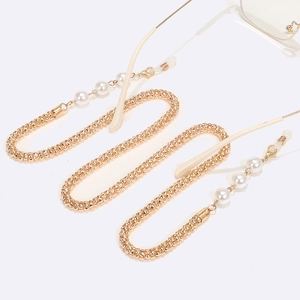 Detail of gold metal eyeglass chain with white pearls and anti-slip silicone loops