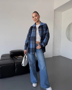 Close-up of a blue plaid flannel shacket paired with denim wide-leg pants for a casual look
