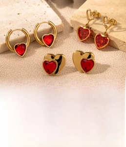 Detail of gold titanium steel earrings with red heart zircon in vacuum plating finish