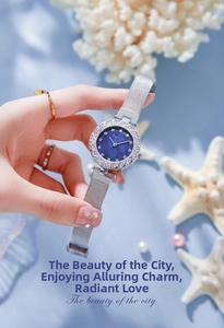 Detailed close-up of a silver mesh strap watch with a blue mother-of-pearl dial
