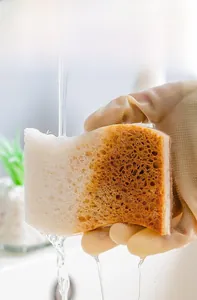 Detail showing wood pulp sponge rinsing under water to separate oil stains effectively