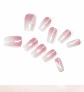Detailed view of pink and white gradient press-on nails with glossy square-oval finish