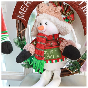 Close-up of a plush snowman in a rustic wreath with Let It Snow knitting detail