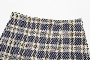 Vue macro détaillée de la texture du tissu en tweed à carreaux et de la taille de la jupe