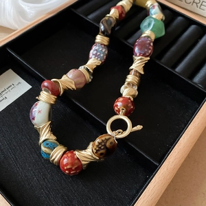 Detailed close-up of retro ceramic beaded necklace with gold metal OT toggle clasp